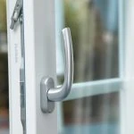 Nahaufnahme eines weißen Fenstergriffs am geöffneten Fenster, Hausbau