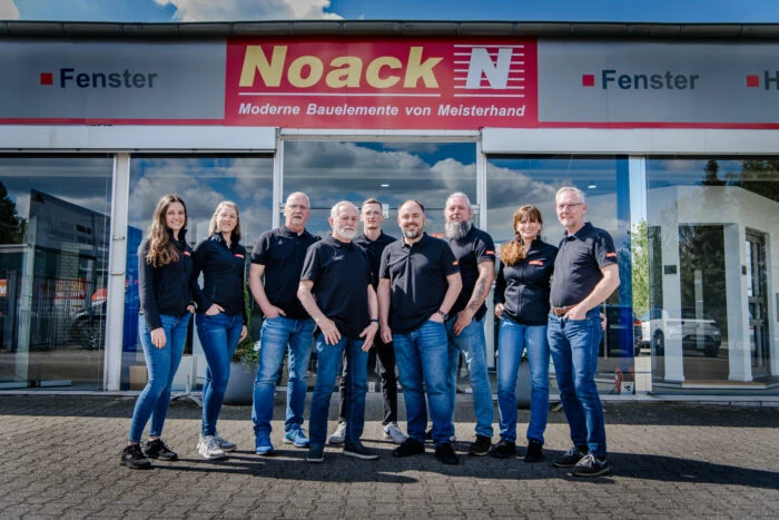 Team von Noack Fensterbau vor Showroom mit Fenstern und Firmenlogo