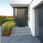 Moderne Haustür mit Stufen, Pflanzkübel und Garage am Eingangsbereich